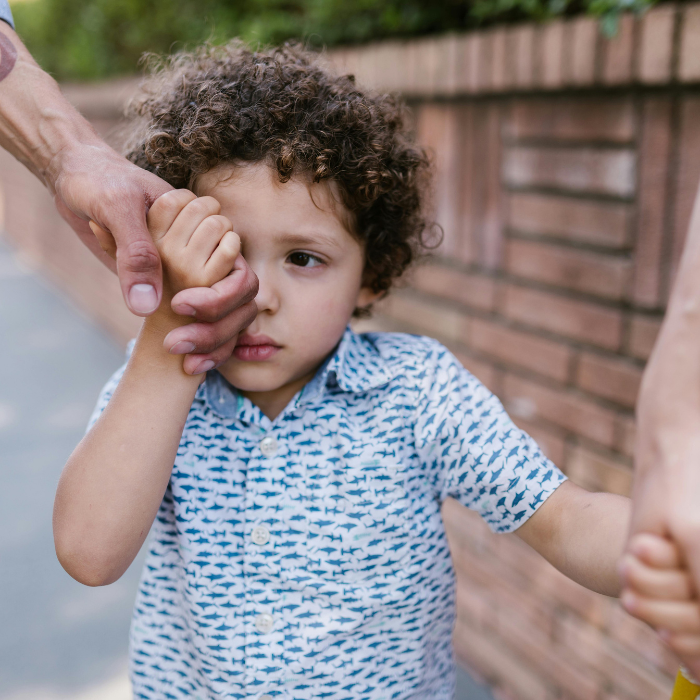 A young boy crying and looking upset, showing signs of anxiety and overwhelm